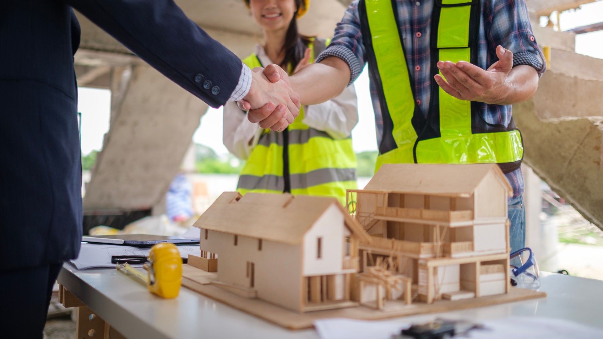 Civil engineer or construction manager with businessman shaking hands at construction site. Building,  and real estate business.